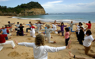 Dru yoga - group performing the Seat of Compassion sequence on the beach