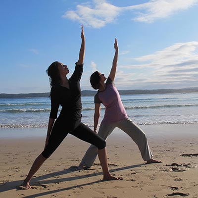 Dru yoga - warrior posture on the beach