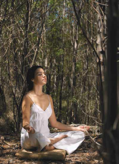 Woman meditating surrounded by trees